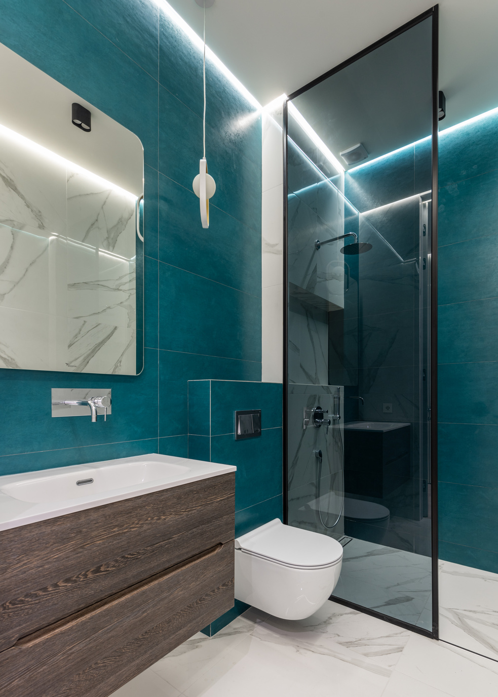 Shower cabin near ceramic toilet bowl and sink in contemporary bathroom